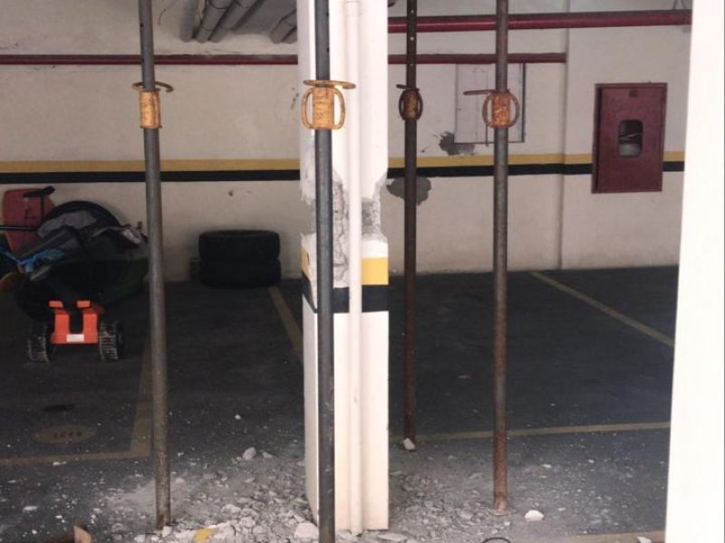 Escoras metálicas apoiando a laje de uma garagem, com entulho de concreto removido no chão