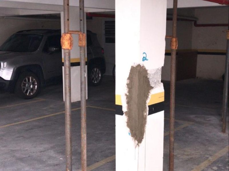 Pilar de garagem com a seção reconstituída, escoras ainda montadas e carro estacionado ao lado