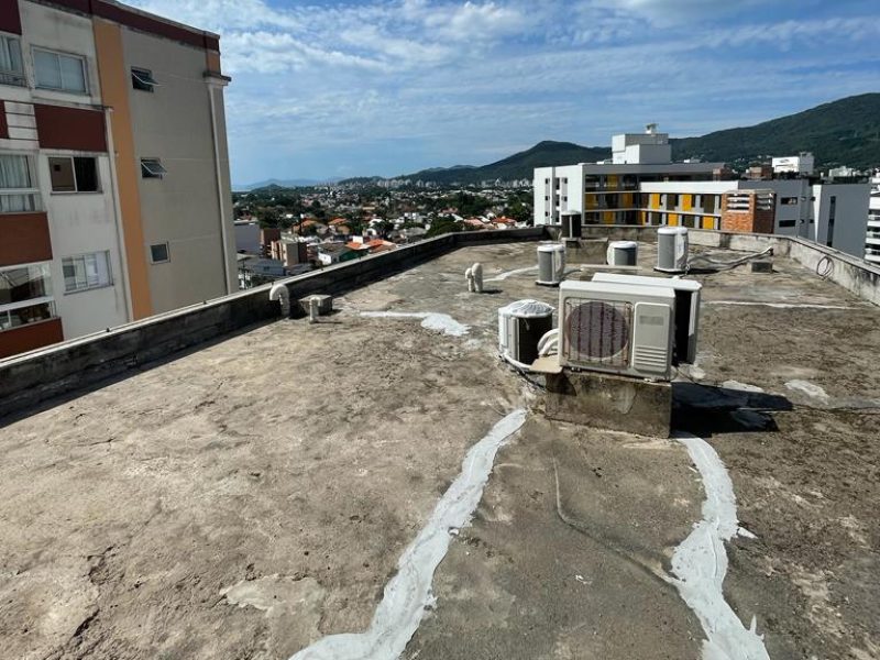 Laje de cobertura já raspada e limpa, com remendos brancos de reparos antigos ainda visíveis