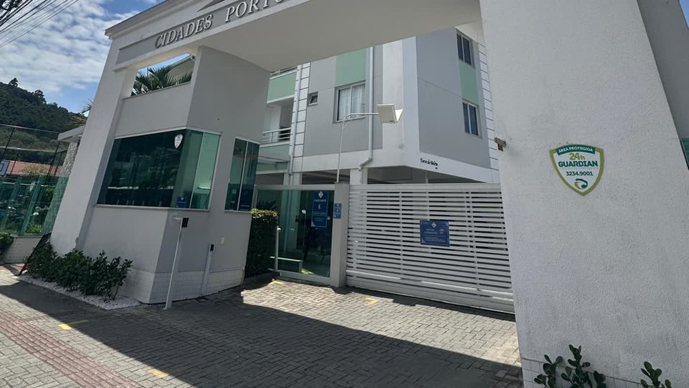 Entrada de condomínio com guarita envidraçada, portão e piso renovados após reforma das áreas comuns