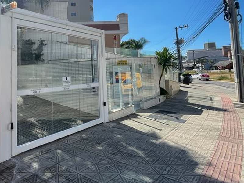 Portão de vidro corrediço e calçada nova na entrada de um condomínio