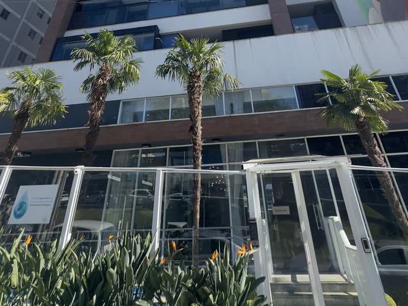 Base de torre residencial com pele de vidro, jardim e acesso térreo modernizados